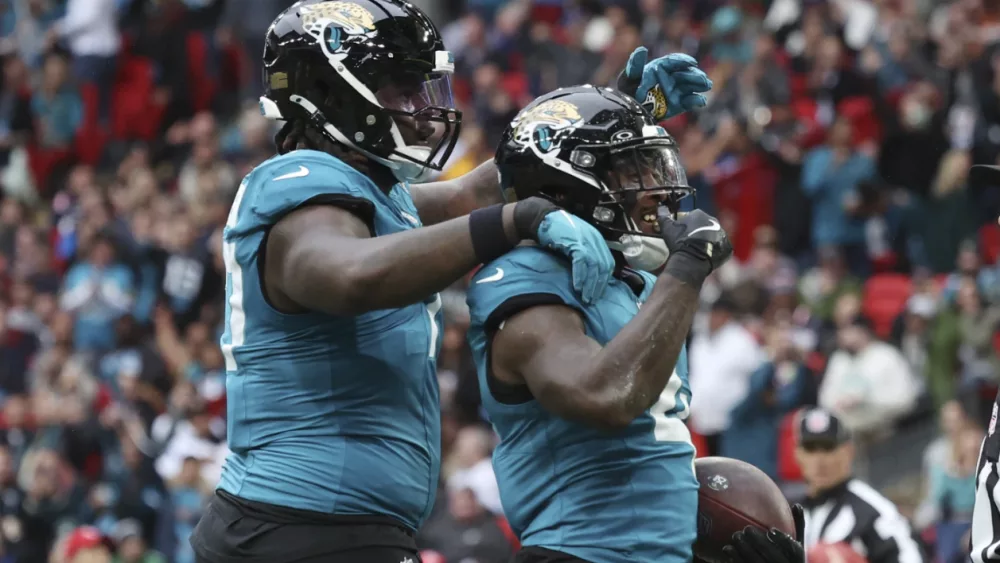 jacksonville-jaguars-running-back-tank-bigsby-right-celebrates-a-1-yard-touchdown-run-against-the-patriots-in-london-671589bbe4f36618650