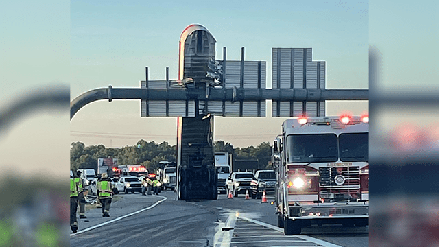 Photo shows trailer stuck upright against sign over Oklahoma highway