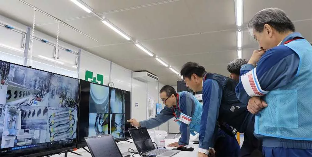 A robot begins removal of melted fuel from Japan's Fukushima nuclear plant. It could take a century