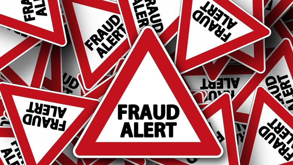 triangular signs with a red outline and the words fraud alert in black capital letters