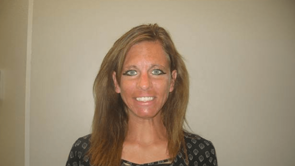 a woman standing in front of a tan wall
