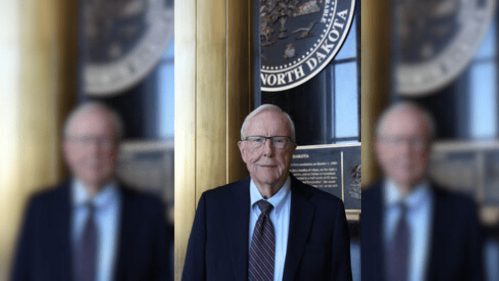 Man standing in front of state seal