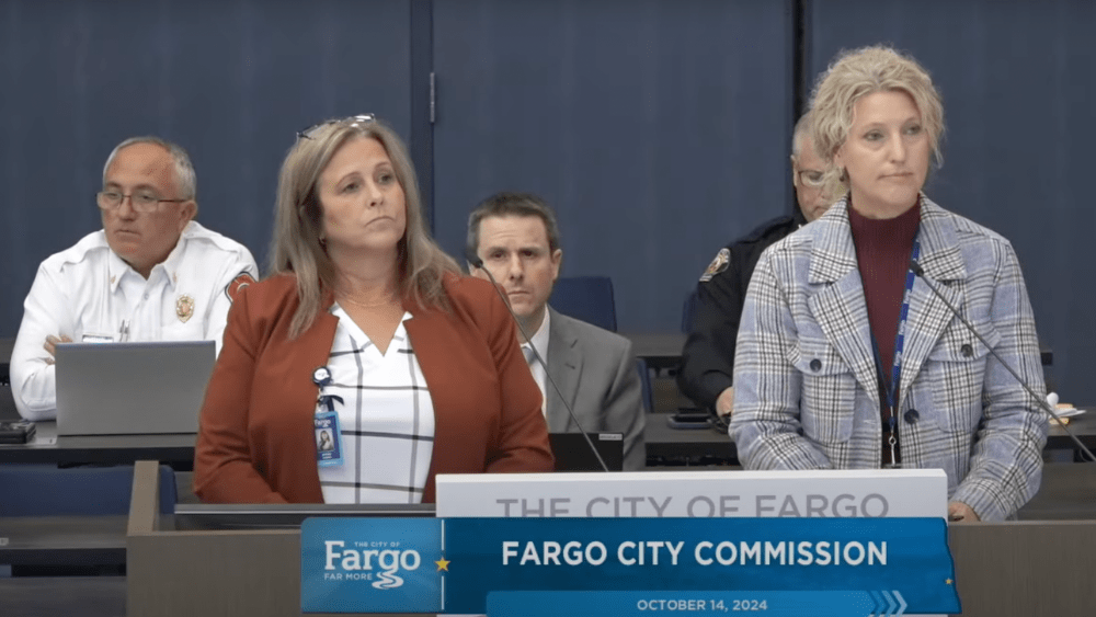 Two women talking at a podium