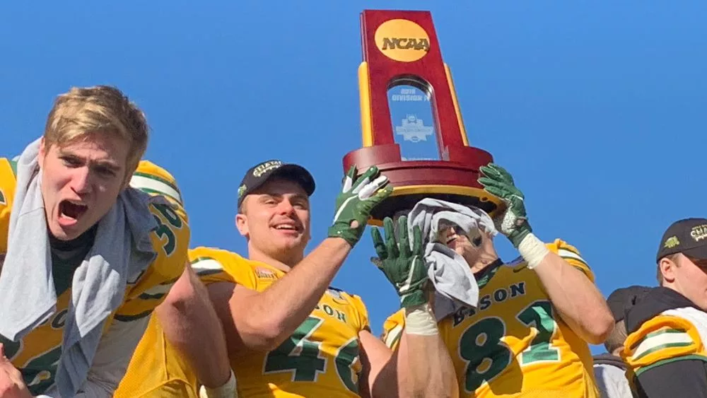 NDSU Football players holding FCS National Championship trophy