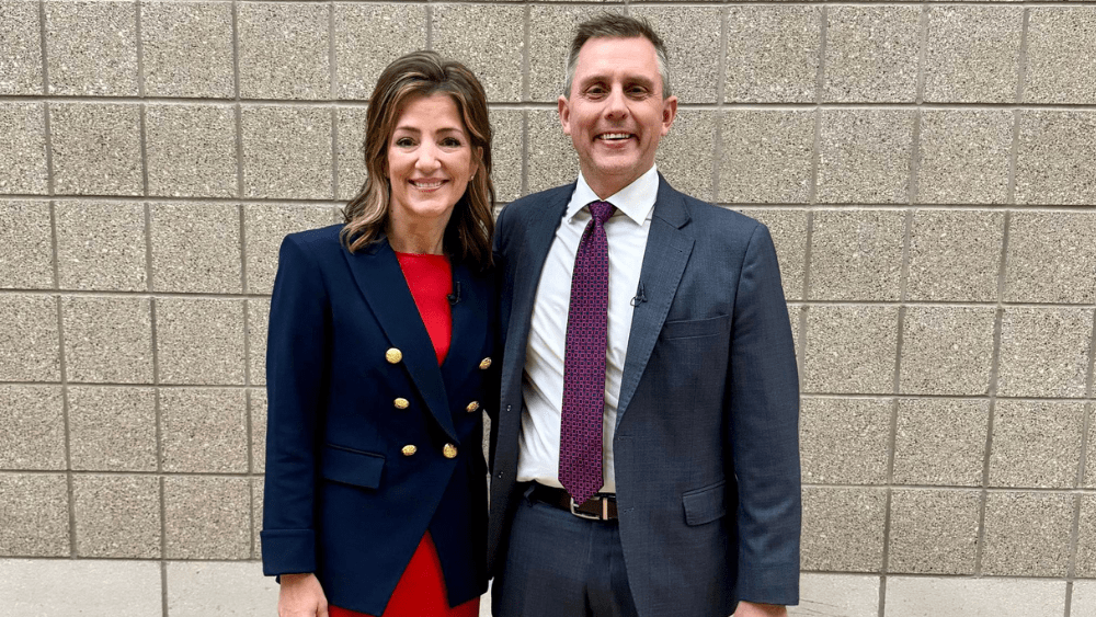 A man and woman in front of a wall