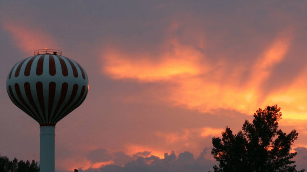 a water tower in a sunsetting sky