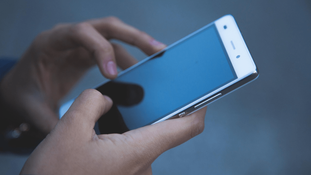 Image of someone holding a phone (hands only)
