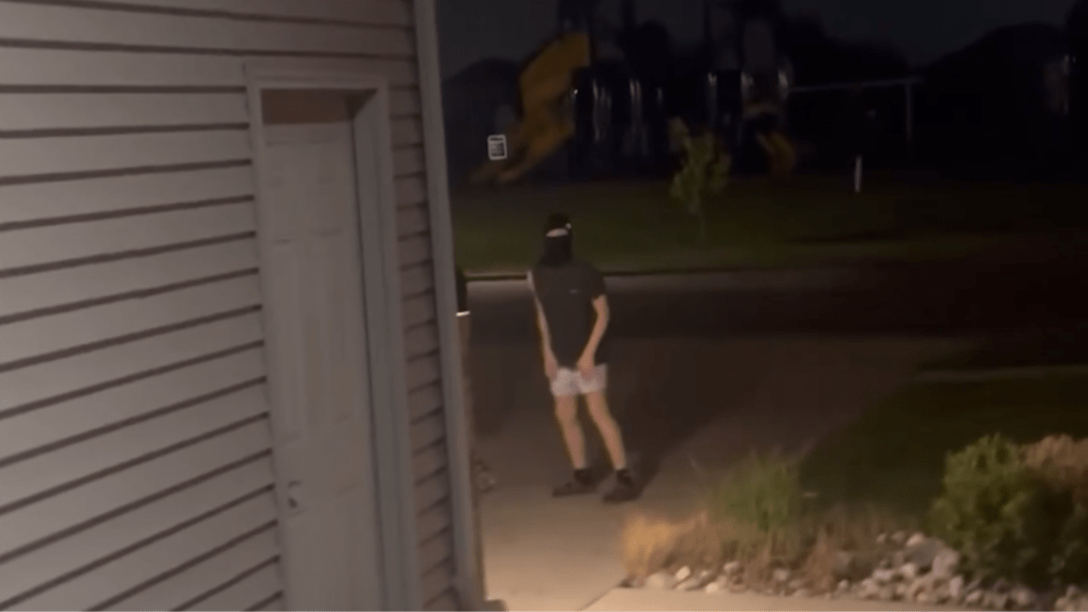 Still image of video showing one of the kids in a ski mask in the driveway