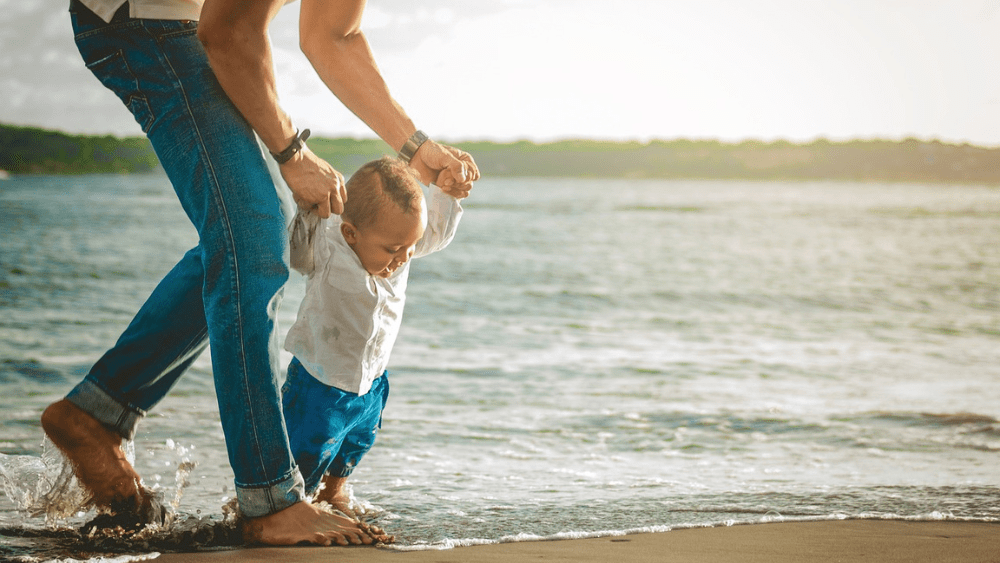 Generic image of father holding his child by his hands as they walk