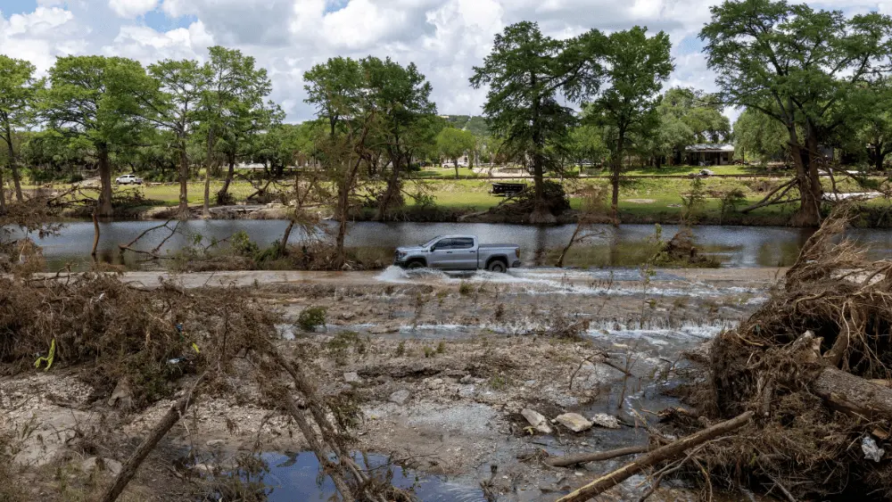 Image of truck driving through Texas flood damage REUTERS