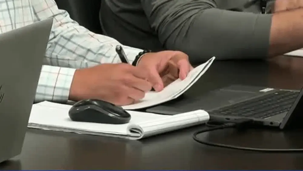 Image of someone writing on a notepad during the West Fargo Short Term Rental Committee meeting