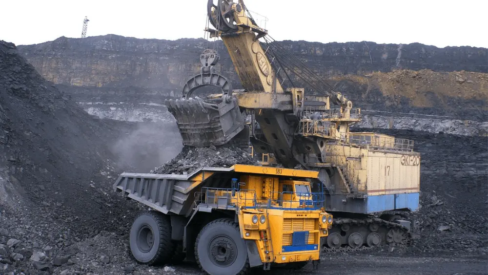 Image of industry vehicles collecting coal at a mine