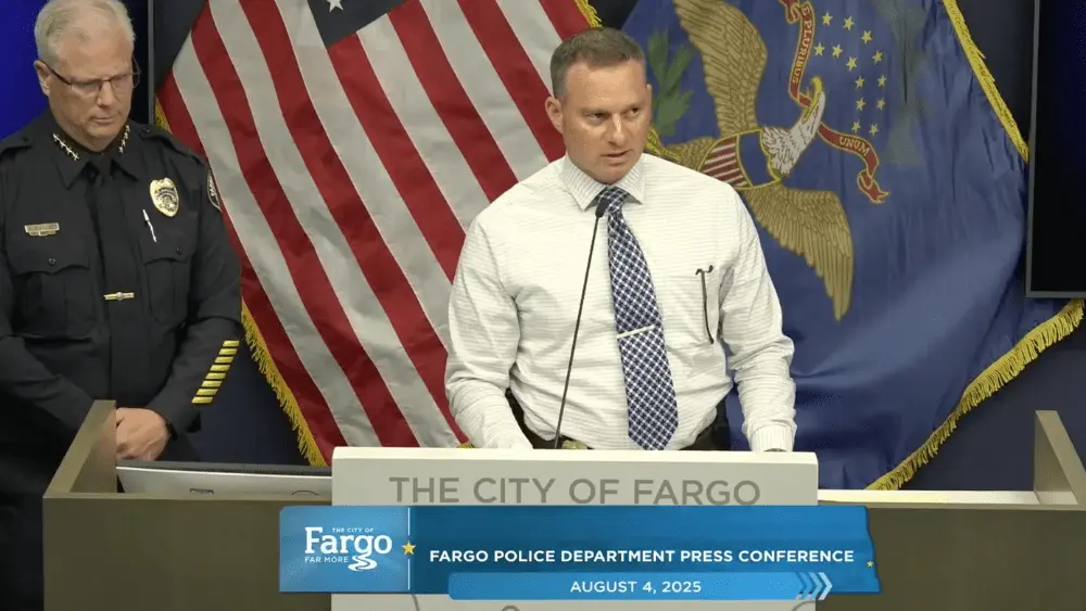 Two men standing in front of an American flag
