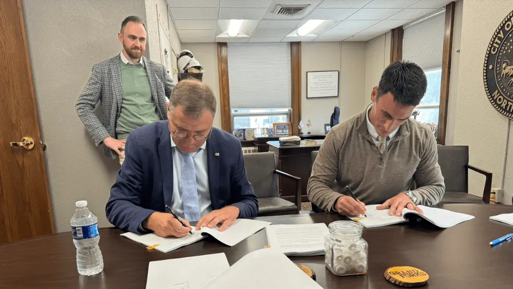 two men signing a documeent