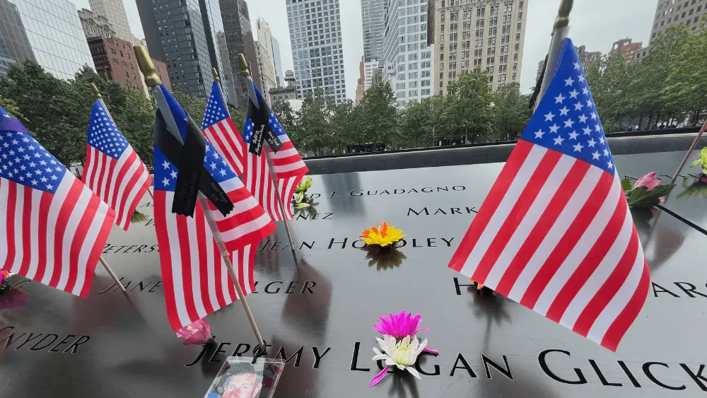 Flags and flowers are placed in the inscribed names