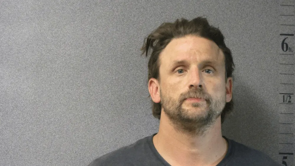 man in front of a gray wall