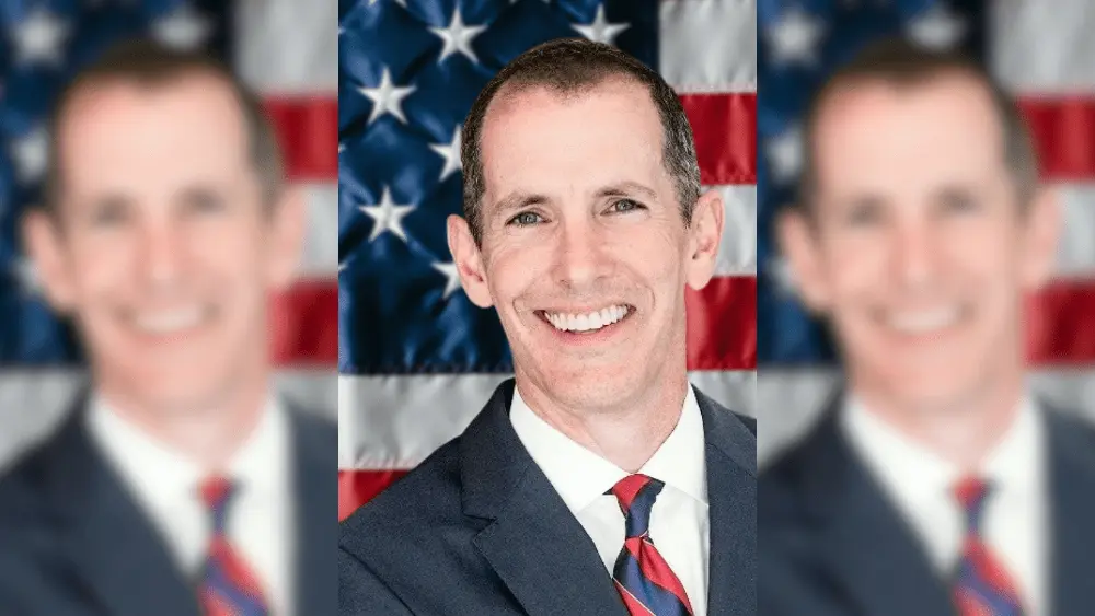 a man in front of a flag