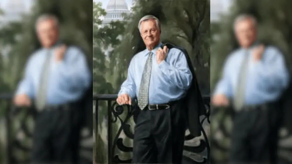 a man in a tie holding a suit jacket over his shoulder