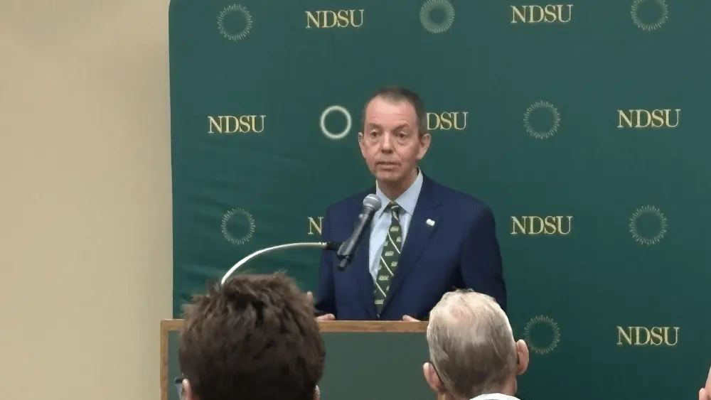 a man in front of an NDSU background