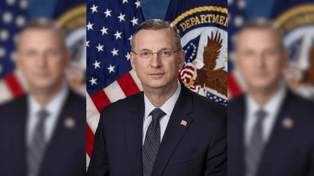 a man in frot of a flag and seal