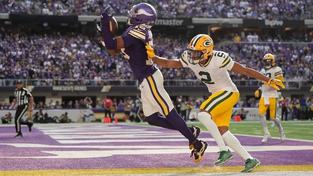 Minnesota Vikings wide receiver Justin Jefferson catches a touchdown pass as Green Bay Packers cornerback Brandon Cisse defends during the first half of an NFL football game^ Sunday^ September 13^ 2026
