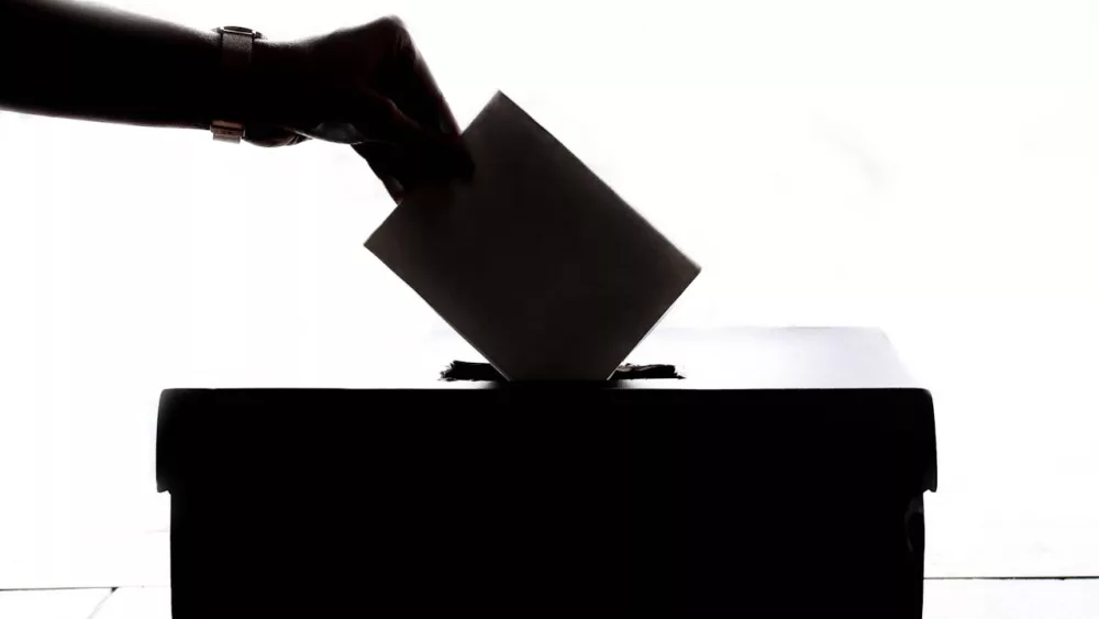 Image of voter dropping ballot in ballot box