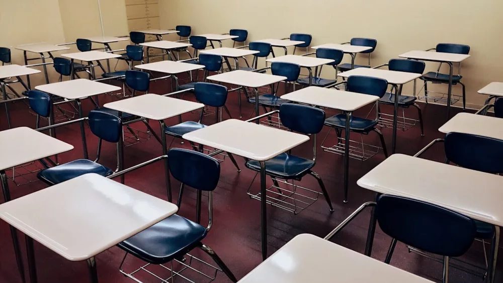 Photo shows desks in a classroom