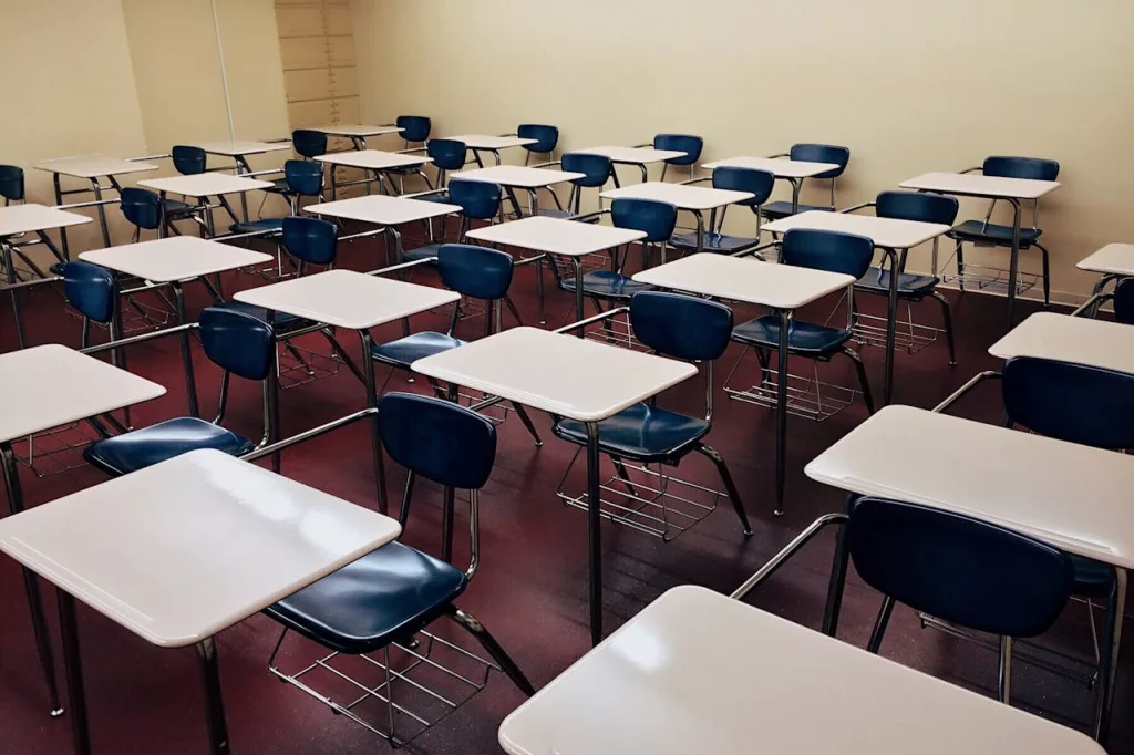 Photo shows desks in a classroom