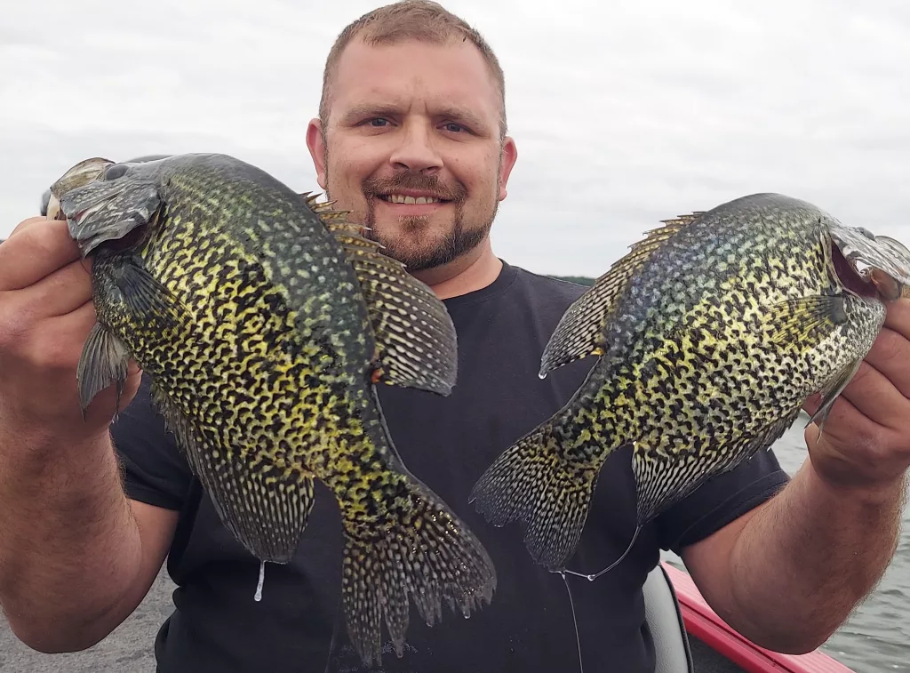 Man holding 2 crappies