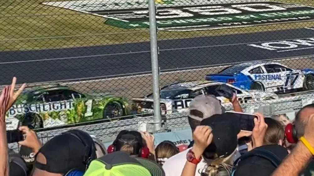 3 Sprint Cars racing around the track with fans cheering