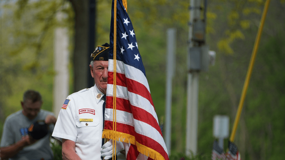 A veteran carrying the United States flag