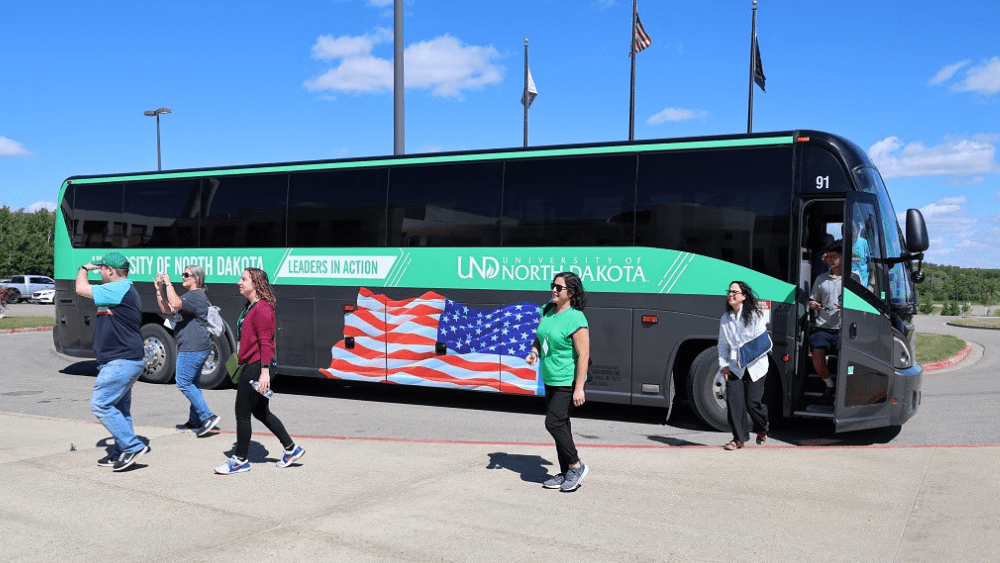 new members of the UND administration and faculty unboard the bus