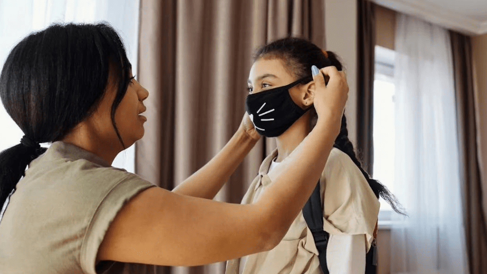 Woman putting a mask over a young girl's face