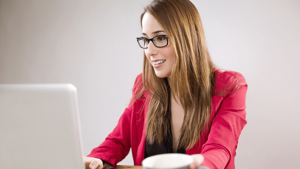 woman working on computer with coffee