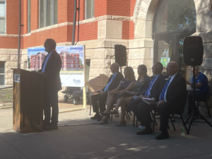 Mark Gorenflo, far left, Chief of Staff and Director for Innovation and Economic Development for the North Dakota University System, addresses those gathered at Mayville State's Old Main Renovation Celebration Friday