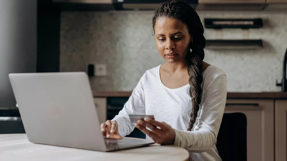 a female with a laptop and a credit card.