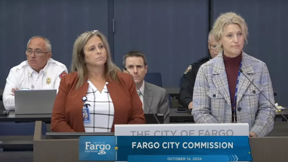 Two women talking at a podium