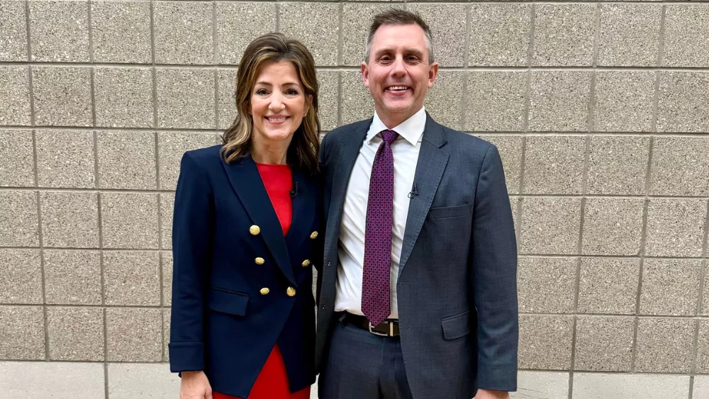 A man and woman in front of a wall