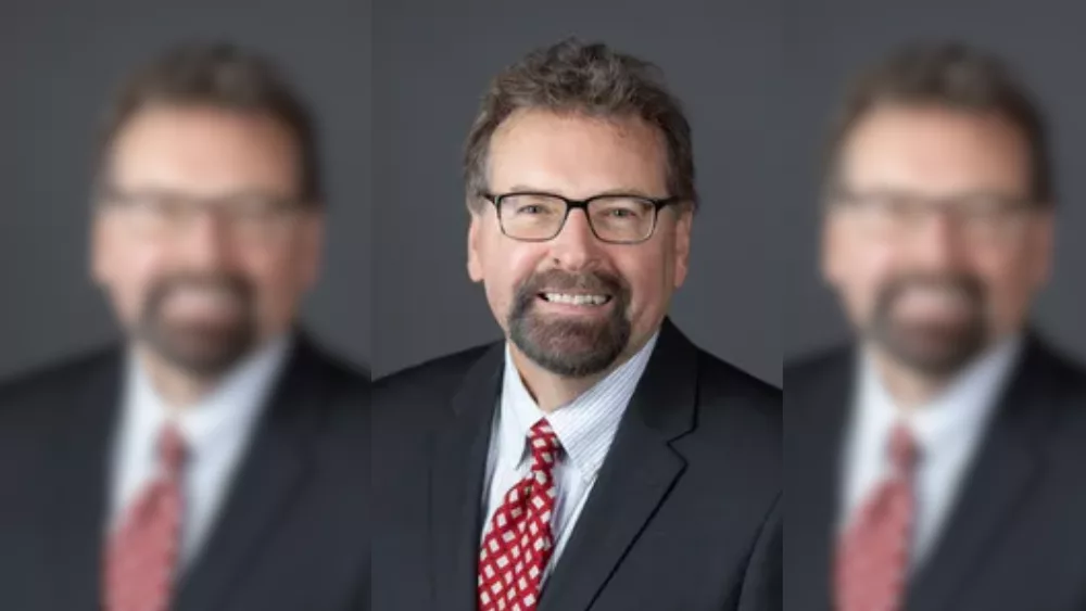 man in a black suit, white shirt and red tie