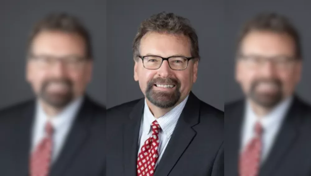 man in a black suit, white shirt and red tie