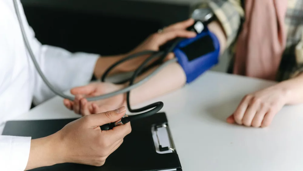 Image of doctor checking a patient's blood pressure during a visit