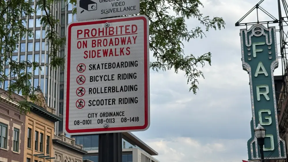 Image of a sign warning people about biking on the sidewalk on Broadway in downtown Fargo