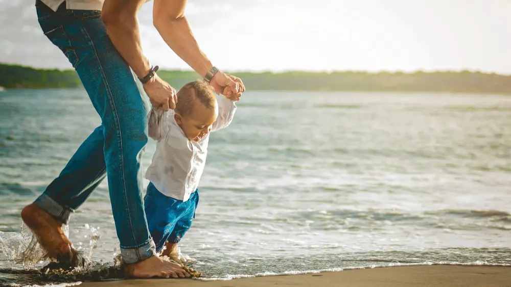 Generic image of father holding his child by his hands as they walk