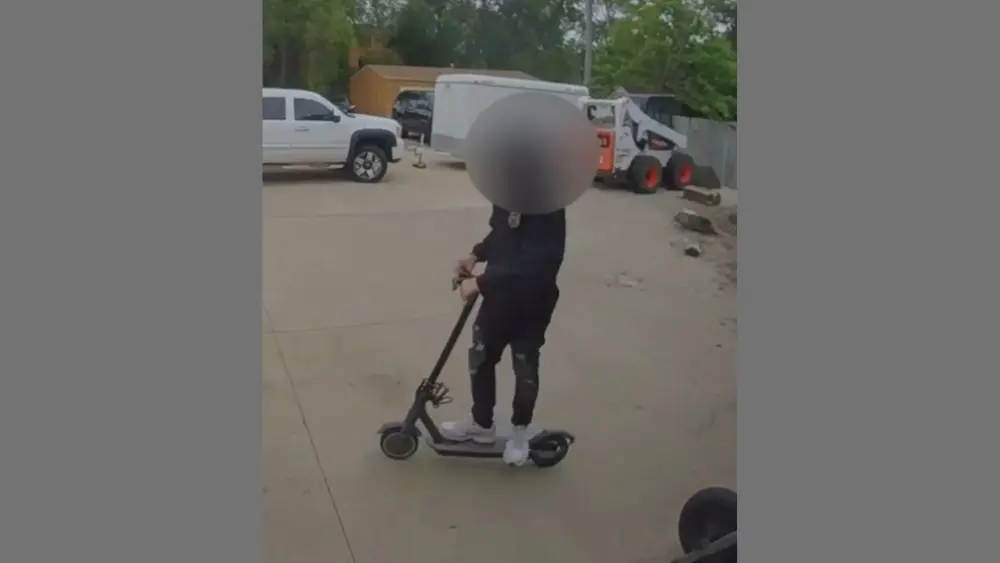 Image of person riding off on a scooter