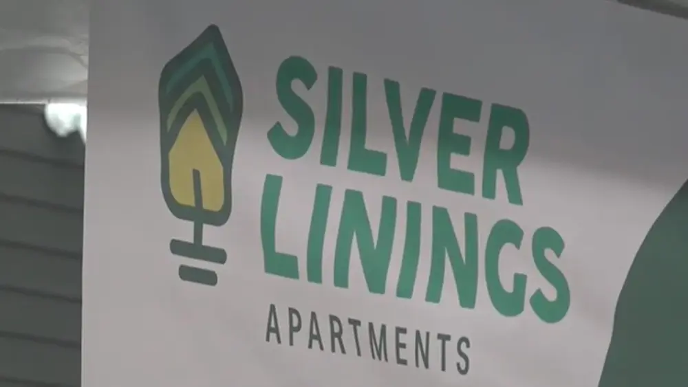 Image of Silver Linings Apartments banner at ribbon cutting ceremony