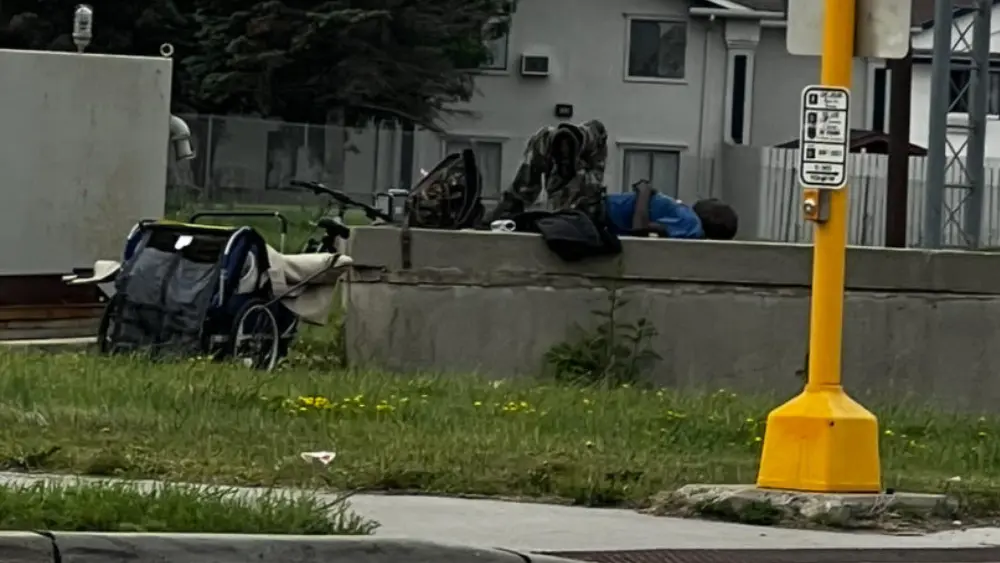 Image of person sleeping on the street at a south Fargo intersection