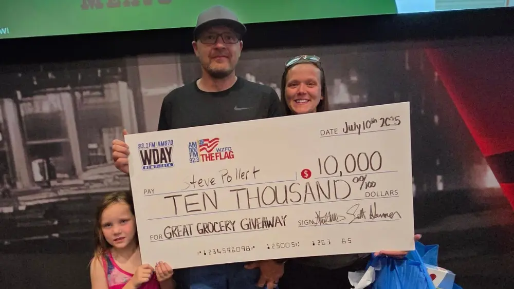 Image of Steve Pollert posing with his family holding the winning 10,000 check