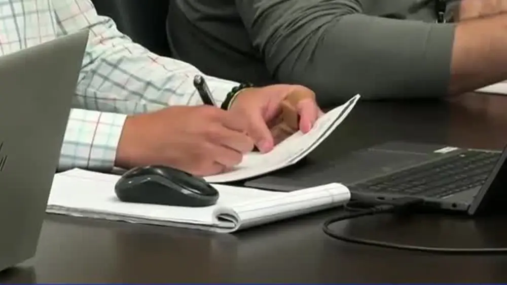 Image of someone writing on a notepad during the West Fargo Short Term Rental Committee meeting