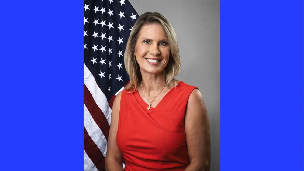 a woman in front of an American flag and gray background