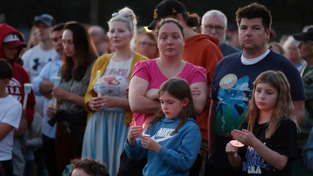 Image of people attending a candlelight vigil for the Minneapolis school shooting victims